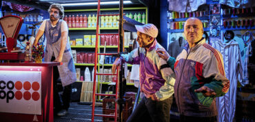 Comédiens dans un décor de Théâtre représentant une épicerie de quartier